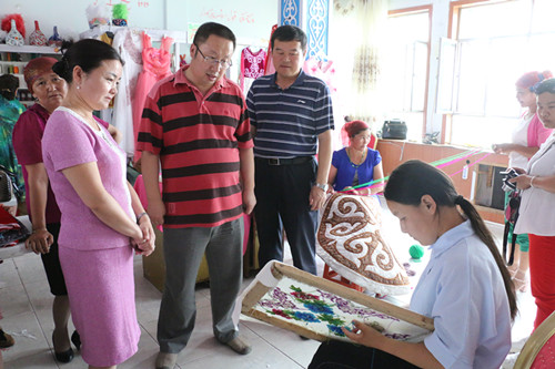 地区残联党组书记、理事长任金铭,县长李胜忠、残联理事长古丽米拉在刺绣基地查看聋哑残疾人刺绣工作