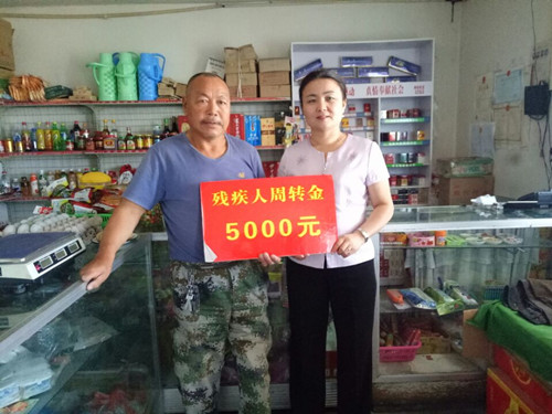 残联理事长古丽米拉为肢残人士陈新玉送去残疾人创业项目资金