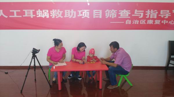 1图为自治区康复中心阿丽米热正在给喀什地区申请人工耳蜗项目的听障儿童进行筛查.jpg