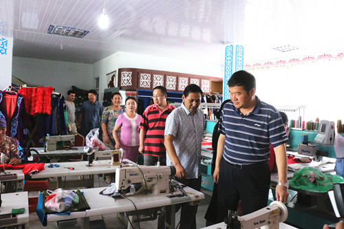 地区残联党组书记、理事长任金铭一行在刺绣基地现场查看